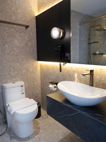 a bathroom with a white toilet and a sink at Merchant Hotel in George Town