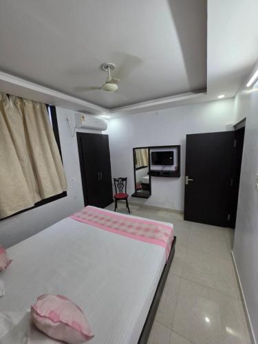 a bedroom with a large white bed with pink sheets at Karma Bodhgaya in Bodh Gaya
