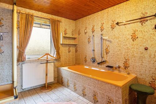 a bathroom with an orange tub and a window at Ferienhaus Adelheid in Bad Grund
