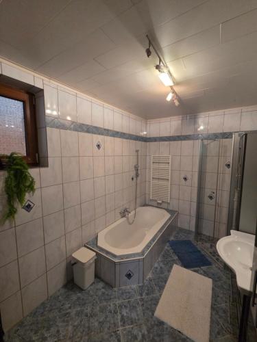 a bathroom with a tub and a sink at Ferienwohnung Tirolerhof in Horn