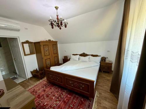 a bedroom with a large bed and a chandelier at Casa cu Dor in Odăile