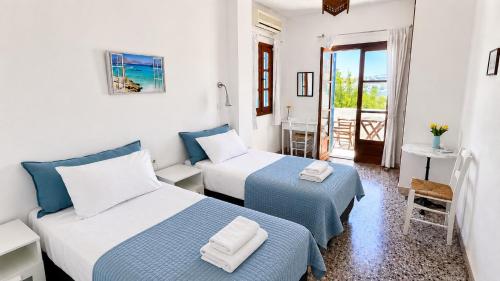 a hotel room with two beds and a balcony at Meltemi Studios and Apartments in Logaras