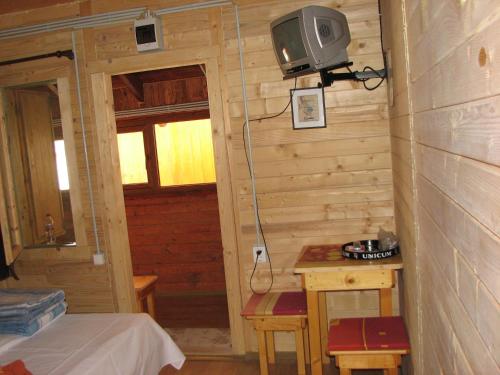 a room with a tv on the wall and a bed at Elga´s Punk Rock Hostel in Vama Veche