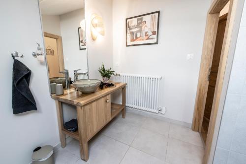 a bathroom with a sink and a bowl on a table at Gîte L'instant Vosges in Aydoilles