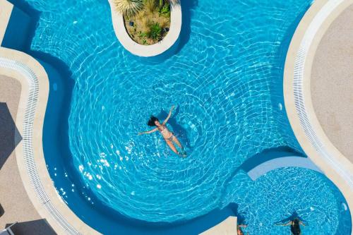 a person swimming in a pool in the water at Anẽse Vacation Feelings in Paliouri