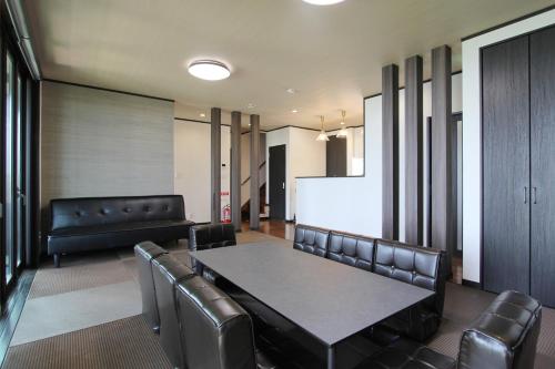 a conference room with a table and leather chairs at ピッコラ カーサ コリーナ 愛犬と泊まれる貸別荘 in Awaji