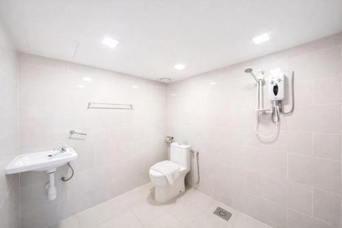a white bathroom with a toilet and a sink at Hotel Seri Warisan Melaka in Malacca