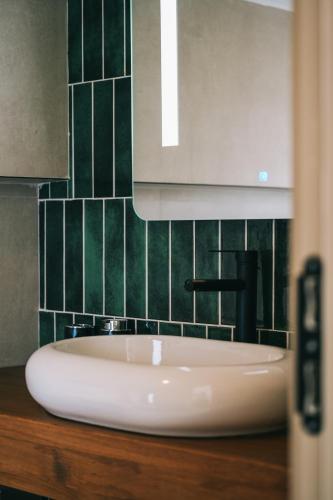 a white sink in a bathroom with green tiles at Rua Sapanca in Sapanca