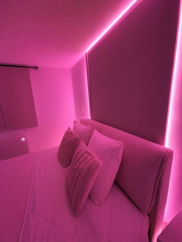 a pink room with a bed with pink pillows at Sweet Escape et Jacuzzi Privé in Gonesse