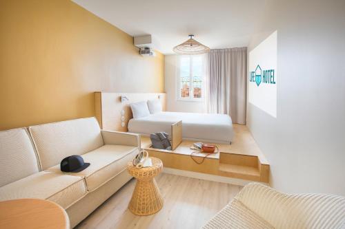 a hotel room with a bed and a couch at Hôtel Life Marseille VP - Vieux Port in Marseille