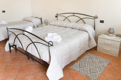 a bedroom with two beds with white sheets at Agriturismo S'Ispiga in Cuglieri