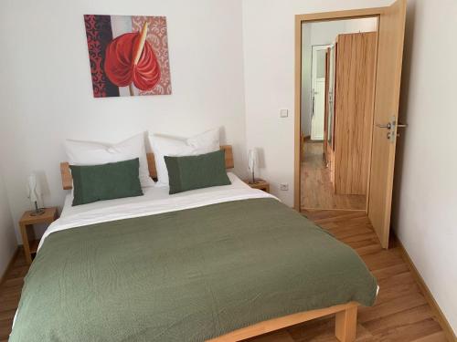 a bedroom with a large bed with a green blanket at Haus Maja in Kurort Rathen