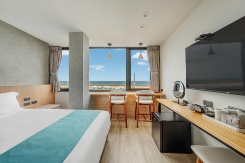 a hotel room with a bed and a large window at 消波塊民宿 in Xiaoliuqiu