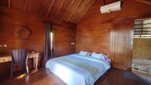 a bedroom with a white bed in a wooden room at FURUSATO BUNGALOW Gili Gede in Gili Gede