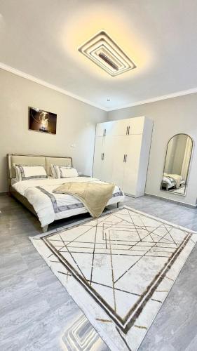 a bedroom with a bed and a rug at Obama Apartments in Mbweni