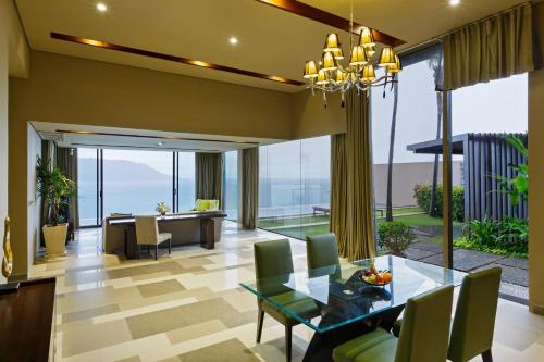 a living room with a glass table and chairs at Impiana Private Villas Kata Noi in Kata Beach