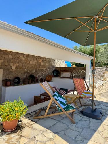 two chairs and an umbrella on a patio at Casa da Curva in Mendiga
