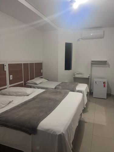 a group of three beds in a room at Hotel Real Centro in São Paulo