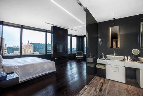 een slaapkamer met een groot bed en een badkamer met een wastafel bij Shenzhen O Hotel in Shenzhen