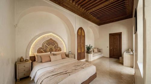 a bedroom with a large bed and a bathroom at Riad Maison Palmier in Marrakesh