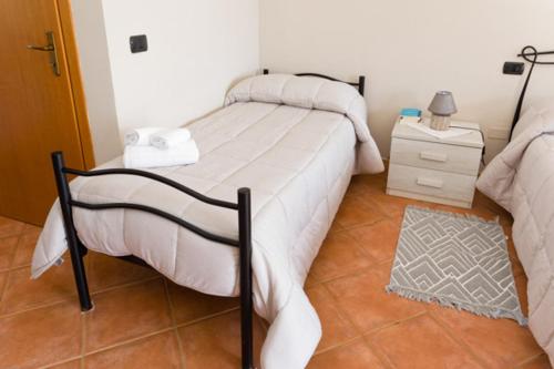a bedroom with a bed and a dresser with a night stand at Agriturismo S'Ispiga in Cuglieri