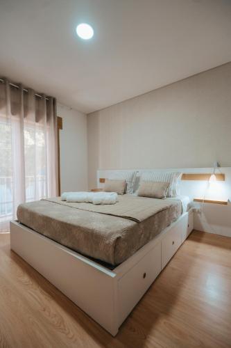 a white bedroom with a large bed in a room at Houses São Pedro in São João da Pesqueira