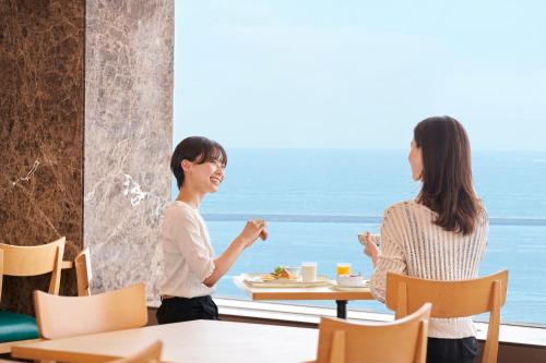 two women sitting at a table talking in a restaurant at Kushiro Prince Hotel in Kushiro