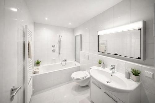 a white bathroom with a sink and a toilet and a tub at Pulheim Living 4 in Pulheim