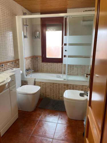 a bathroom with a tub and a toilet and a sink at Apartamento Uno in Guadalaviar