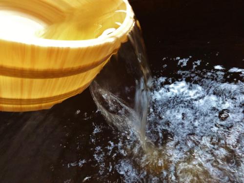 a bowl of water next to a yellow bowl at Tenryuso in Ōtaki