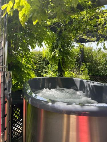 a large tub filled with water next to a tree at Bridleway Bed & Breakfast in Lincoln