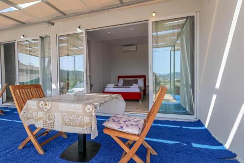 a room with a table and chairs and a bed at Vila Bliss in Ksamil