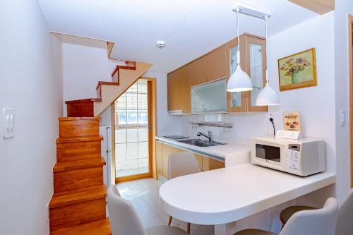 a kitchen with a white table and a microwave at Dyne Resort in Jeju