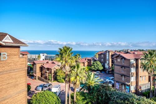 an aerial view of a residential neighborhood with palm trees and the ocean at Dyne Resort in Jeju