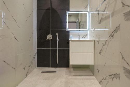 a bathroom with a shower and a sink and a mirror at Vila Bliss in Ksamil