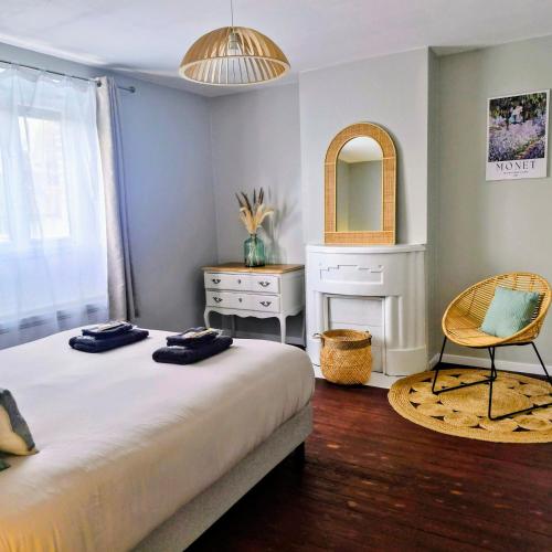 ein Schlafzimmer mit einem Bett, einem Spiegel und einem Stuhl in der Unterkunft La Petite Maison de Vernon-Giverny, gîte cosy avec jardin à 7 min de Giverny, Sauna, Wifi, parking gratuit dans la rue, calme in Vernon