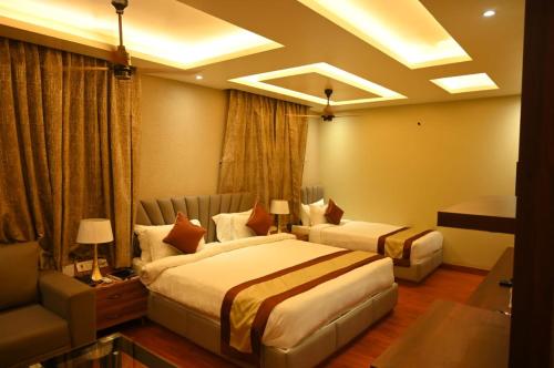 a hotel room with two beds and a couch at The Vaishnavi Hotel , Buxar Bihar in Buxar