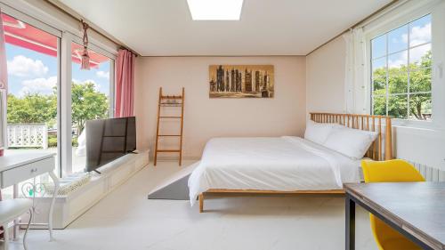 a bedroom with a bed and a tv and a desk at Chuncheon Happysday Pet-Friendly Pension in Chuncheon