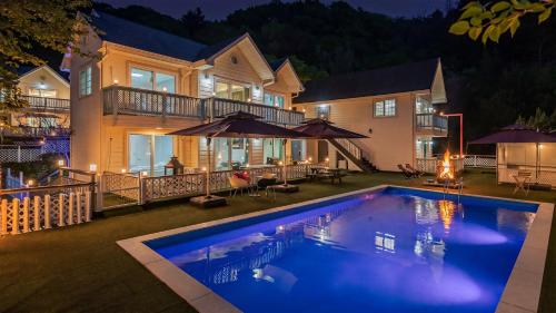 a house with a swimming pool in front of a house at Chuncheon Happysday Pet-Friendly Pension in Chuncheon