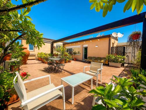 a patio with white chairs and a table at B&B Pellicano Guest House in Reggio di Calabria