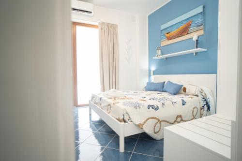 ein blau-weißes Schlafzimmer mit Bett und Fenster in der Unterkunft Affittacamere Iside in Sapri