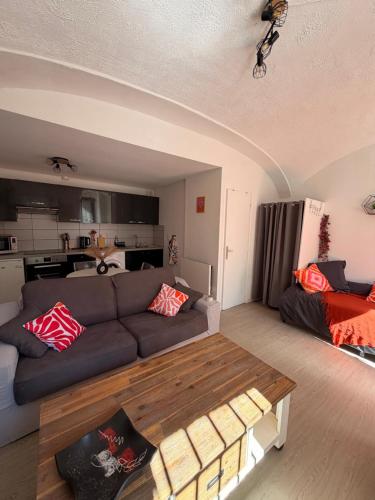 a living room with a couch and a table at Studio centre du village in Tende