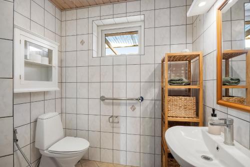 a bathroom with a toilet and a sink at Lærke-huset in Bindslev