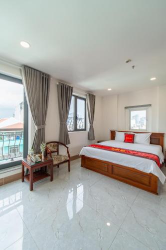 a bedroom with a large bed and a large window at Apogee Hotel in Ho Chi Minh City