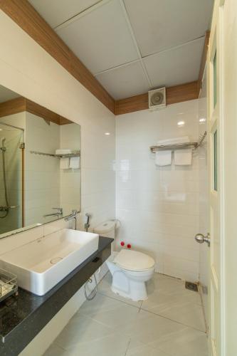 a bathroom with a tub and a toilet and a sink at Apogee Hotel in Ho Chi Minh City
