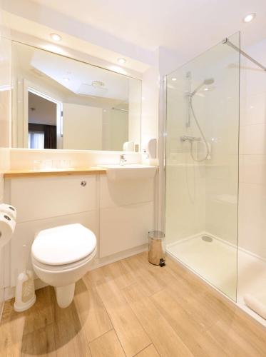 a bathroom with a toilet and a glass shower at Travelodge Plus Galway in Galway