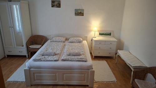 a bedroom with two beds and a dresser at Éva Apartmanház 2 in Csopak