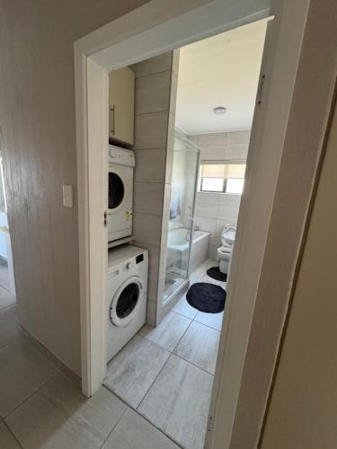 a laundry room with a washer and dryer in it at Oceanview Stays in Great Brak River