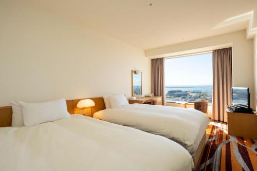a hotel room with two beds and a large window at Kushiro Prince Hotel in Kushiro