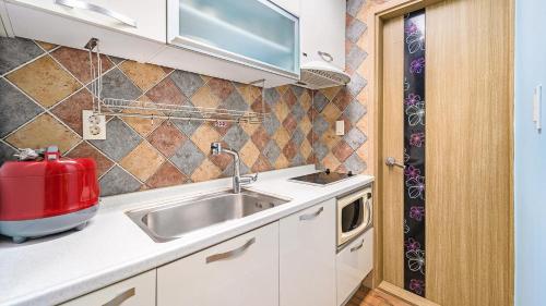 a kitchen with a sink and a red appliance at Geoje Araon Pension in Geoje